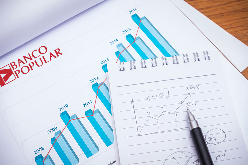 Imagen cuaderno y bolígrafo sobre un gráfico del banco popular